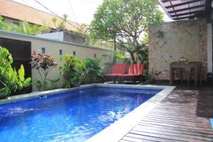 a swimming pool in the middle of a yard at Ketut Villa Sanur in Sanur