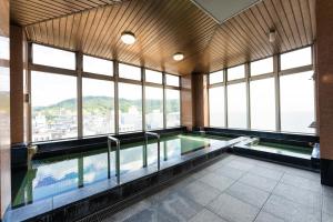 einen Pool in einem Gebäude mit Fenstern in der Unterkunft Hotel Ark 21 in Kurayoshi