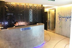 a woman sitting at a reception desk in a hotel lobby at Blutique Hotel in Bangkok