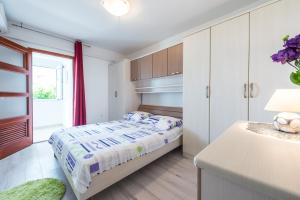 a white bedroom with a bed and a window at Guest House Kuna in Dubrovnik