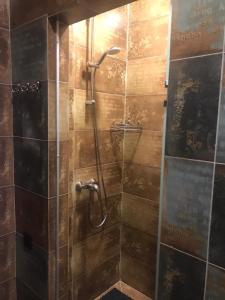 a shower with a glass door in a bathroom at Sulu Hostel in Astana