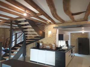 una cocina con una escalera de caracol en un loft en Le Sourire du Troubadour - 8 chambres - Baignade à 300 m - Salle de jeux - Poêle à bois, en Daglan