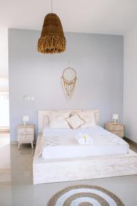 a bedroom with a white bed with a rug on the floor at Villa Uhaïna Amed Bali in Amed