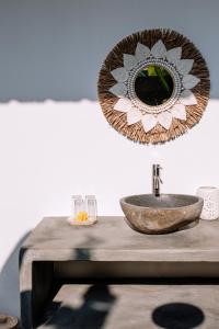 a mirror on top of a wooden table with a sink at Villa Uhaïna Amed Bali in Amed
