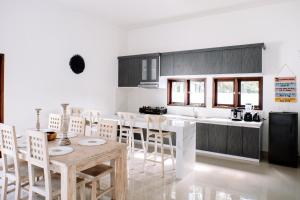 a kitchen with a table and chairs in a kitchen at Villa Uhaïna Amed Bali in Amed
