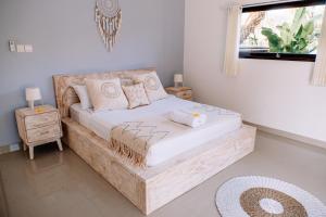 a bedroom with a large wooden bed with a window at Villa Uhaïna Amed Bali in Amed