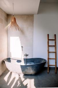 Habitación con baño con bañera grande. en Villa Uhaïna Amed Bali, en Amed