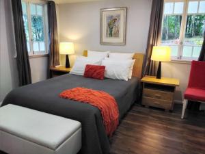 una camera da letto con un letto con una coperta rossa sopra di Keillor Lodge a Maleny