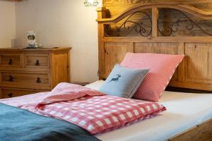 a bed with a wooden headboard and pillows on it at Haus Ditzer - Villa Theresia in Zell am See