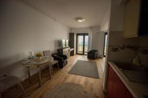 een kleine woonkamer met een tafel en een keuken bij Black Sea Booking - Munchen in Mamaia Nord – Năvodari