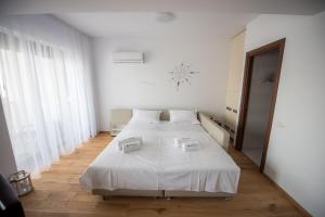 een witte slaapkamer met een bed met twee dozen erop bij Black Sea Booking - Munchen in Mamaia Nord – Năvodari