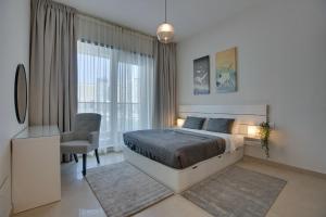 a bedroom with a bed and a desk and a chair at 5* Brand New Sparkle Tower by Swarovsky in Dubai