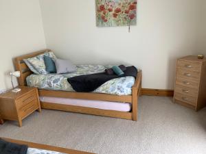 una camera con letto in legno e cassettiera di Waters Edge a Penclawdd