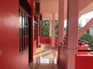 un pasillo vacío de un edificio con paredes rojas en RedDoorz near Politeknik Negeri Lampung, en Lampung