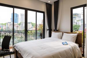 1 dormitorio con 1 cama grande y balcón en Mersey Central Hanoi Apart'Hotel en Hanoi