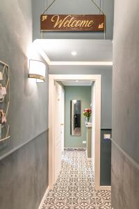 pasillo con señal de bienvenida y suelo de baldosa en La Lu cozy rooms 2 - Self check-in, en Pisa