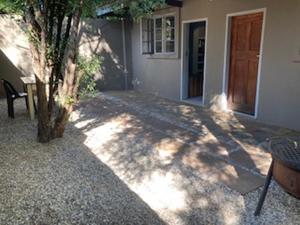 a house with a table and a tree in front of it at 31 at Murray in Pretoria