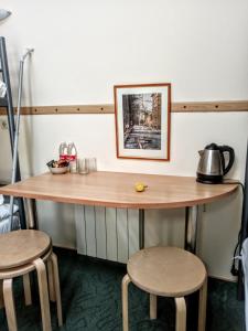 a table with stools and a tea kettle on it at Kurskaya 10 Mini-Hotel in Saint Petersburg
