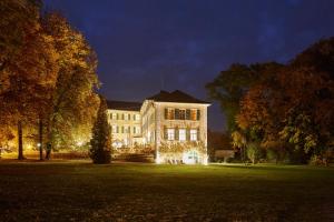 un gran edificio con luces de Navidad en un patio por la noche en Schloss Burgellern, en Scheßlitz