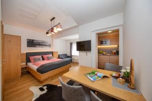 a bedroom and living room with a bed and a table at Haus Ditzer - Villa Theresia in Zell am See