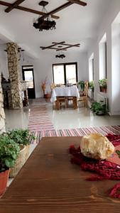 a living room with a table and a dining room at Pensiunea Drumul Iancului in Vidra