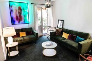 a living room with a green couch and two tables at Villa A Hotel in Odense