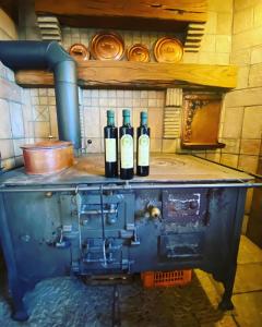 tres botellas de vino sentadas encima de una máquina en All'Antica Scuderia Del Castello, en Maiano