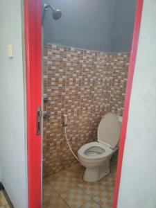 Habitación con suelo de baldosa y baño con aseo. en Adihan Homestay Mitra RedDoorz, en Palangkaraya