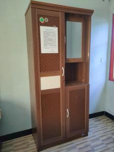 Adihan Homestay Mitra RedDoorz في بالانجكارايا: خزانة خشبية مع باب زجاجي في الغرفة