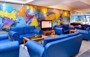 een lobby met blauwe banken en een grote muurschildering bij Hotel Laguna Mare in Albena