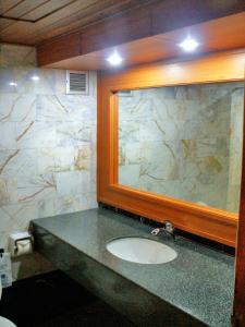 a bathroom with a sink and a mirror at Royal Twins Palace Hotel in Pattaya Central