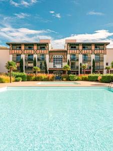 a building with a swimming pool in front of a building at La bulle de Lily in Moliets-et-Maa