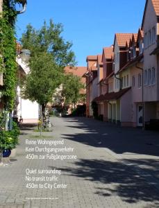a street in a town with a tree and buildings at Domizil Domblick Speyer City, Garage, 50m2 in Speyer