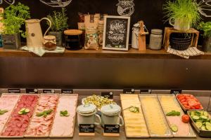 a kitchen counter filled with lots of different types of food at Motel One Berlin-Tiergarten in Berlin