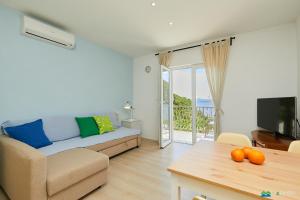 een woonkamer met een bank en een tafel bij Mljet 2 You - seafront apartment 2+2 in Sobra