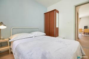a bedroom with a large white bed and a table at Mljet 2 You - seafront apartment 2+2 in Sobra