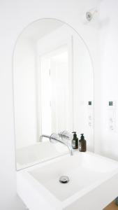 a white bathroom with a sink and a mirror at Haus Münsterblick in Reichenau +48 photos