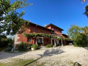 ein großes rotes Haus mit Kieseinfahrt in der Unterkunft All'Antica Scuderia Del Castello in Maiano