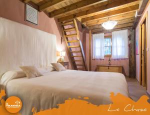 a bedroom with a large bed and a staircase at La Volandera in Jerez de la Frontera