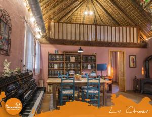 uma sala de jantar com uma mesa e um piano em La Volandera em Jerez de la Frontera