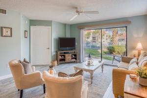 a living room with a couch and a tv at Driftwood Escape in Saint Augustine Beach