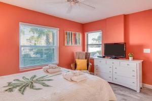 1 dormitorio con paredes de color naranja y 1 cama con TV en Driftwood Escape, en Butler Beach