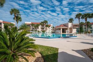 a pool at a resort with palm trees and condos at Driftwood Escape in Butler Beach