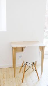 a white chair sitting next to a wooden desk at Haus Münsterblick in Reichenau