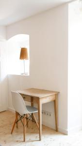 einen Schreibtisch und einen Stuhl in einem Zimmer mit einer Lampe in der Unterkunft Haus Münsterblick in Reichenau