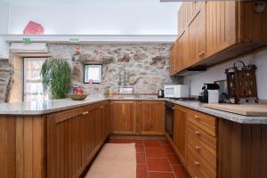ForneloにあるCasa da Cercaの石壁のキッチン(木製キャビネット付)