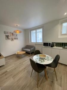 ein Wohnzimmer mit einem Tisch und Stühlen in der Unterkunft Appartement cosy proche RER et centre ville in Le Plessis-Robinson