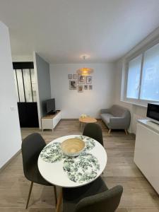 - un salon avec une table et des chaises dans l'établissement Appartement cosy proche RER et centre ville, au Plessis-Robinson
