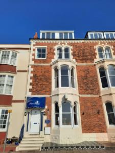a red brick building with a white door and windows at Penn House Hotel in Weymouth