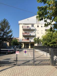 um edifício branco com uma cerca em frente em Appartamento al Mare em Martinsicuro